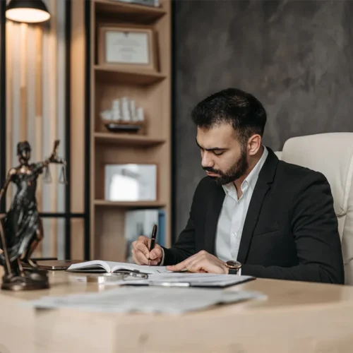 Avocat masculin signant des papiers assis dans son bureau